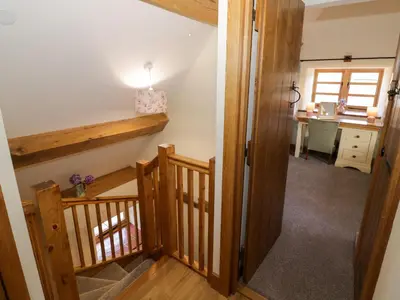a hallway with a stairway leading to a kitchen at Grove Farm in Church Stretton