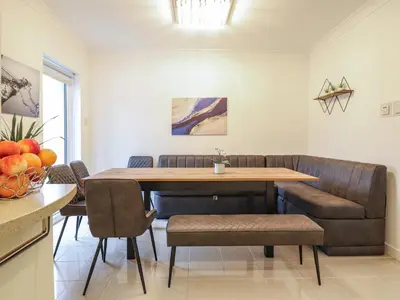 a dining room with a table and a couch at Gwylanod in Llwyngwril