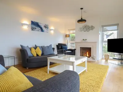 a living room with a couch and a fireplace at Gwylanod in Llwyngwril