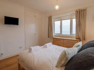 a bedroom with a bed with two towels on it at Gwylanod in Llwyngwril