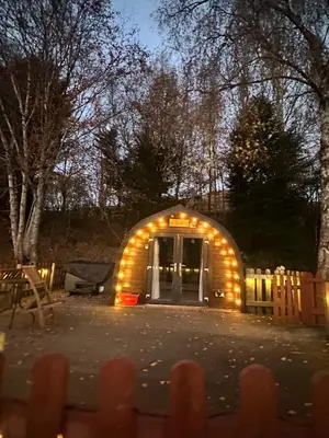 a small house with lights in a yard at night at Glamping Life Retreat in Nantmel