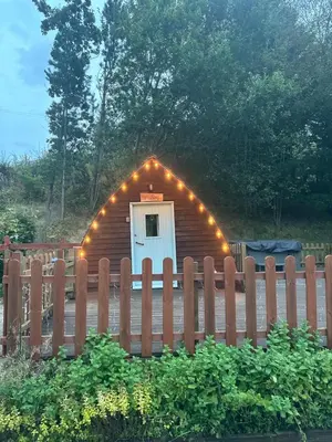 a small cabin with lights on it behind a fence at Glamping Life Retreat in Nantmel