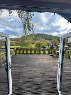 an open door to a deck with a view of the yard at Glamping Life Retreat in Nantmel