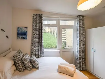 a bedroom with a bed and a large window at The Glass House in Aberdyfi