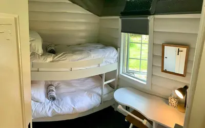 two bunk beds in a small room with a window at Caban Marjie in Trawsfynydd
