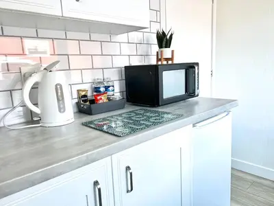 a kitchen counter with a microwave and a tv on it at Chalet 7 Erw Porthor in Tywyn