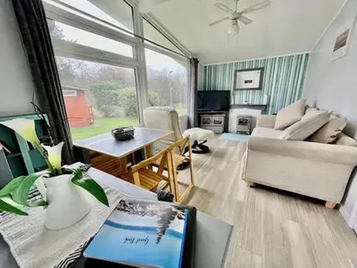 a living room with a couch and a table at Chalet 7 Erw Porthor in Tywyn