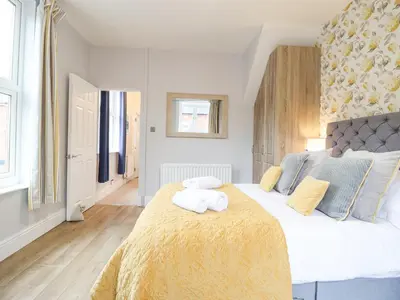 a bedroom with a large bed with two towels on it at Tŷ Kinik in Llangollen