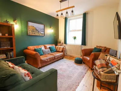 a living room with two couches and a window at Tŷ Kinik in Llangollen