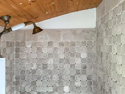 a bathroom with a stone wall with a light on it at Myfanwy in Ciliau-Aeron