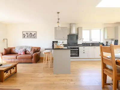 a kitchen and living room with a couch and a table at Bryn Bras in Corwen