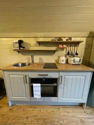 a small kitchen with a sink and a counter top at Damson Lodge in Hereford