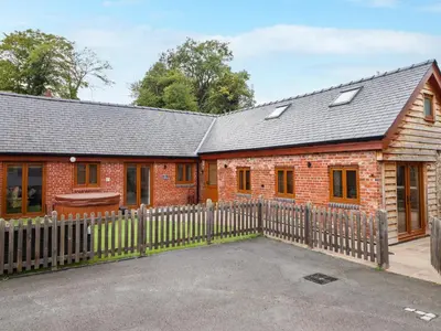 a red brick house with a wooden fence at The Granary in Montgomery