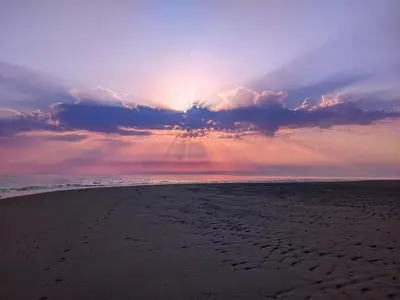 a view of a beach with the sun setting at Cartref Guesthouse - Room 1 Ensuite in Aberdyfi