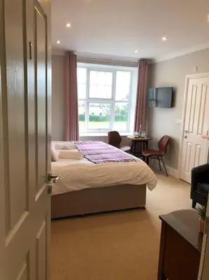 a bedroom with a bed and a desk and a window at Cartref Guesthouse - Room 1 Ensuite in Aberdyfi