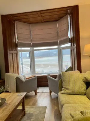 a living room with a large window with a view of the ocean at Wynnstay Apartment, Harbour and Mountain Views in Barmouth