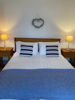 a bedroom with a bed with pillows and two lamps at Wynnstay Apartment, Harbour and Mountain Views in Barmouth