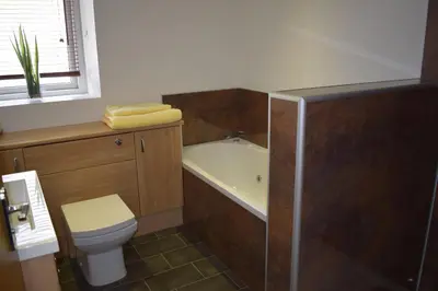 a bathroom with a tub and a toilet and a sink at Wynnstay Apartment, Harbour and Mountain Views in Barmouth