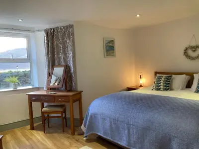 a bedroom with a bed and a desk and a window at Wynnstay Apartment, Harbour and Mountain Views in Barmouth