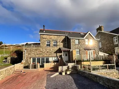 a large stone house with a brick driveway at Bryn Glasfor in Barmouth