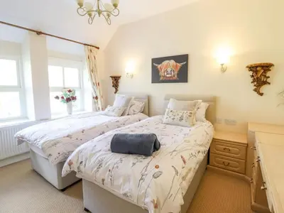 a bedroom with two twin beds and a dresser at Bryn Glasfor in Barmouth