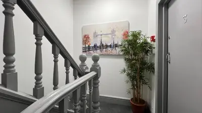 a staircase with a painting on the wall and a plant at Barmouth Beach Front Apartments in Barmouth