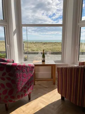 a room with a table and two chairs and a window at Barmouth Beach Front Apartments in Barmouth