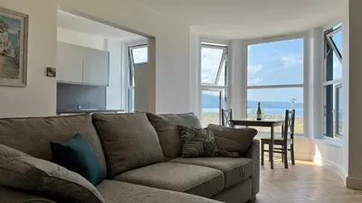 a living room with a couch and a table at Barmouth Beach Front Apartments in Barmouth