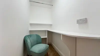 a room with a desk and a green chair at Barmouth Beach Front Apartments in Barmouth