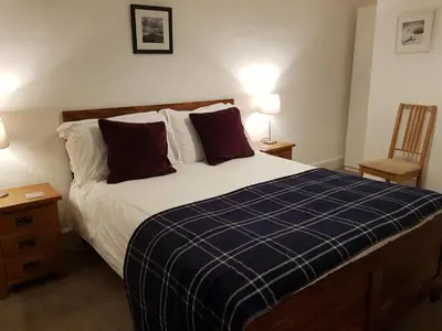 a bedroom with a bed with a blue plaid blanket at Ty Helyg Guest House in Brecon