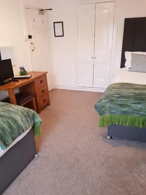 a bedroom with two beds and a desk with a computer at Ty Helyg Guest House in Brecon