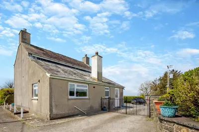 an old house with a gate in front of it at 3 Bed in Llanrhystud oc-m28913 in Llanrhystyd