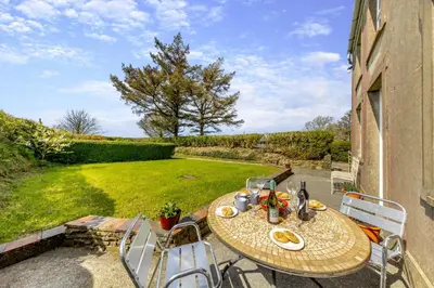 a table and chairs on a patio with a yard at 3 Bed in Llanrhystud oc-m28913 in Llanrhystyd