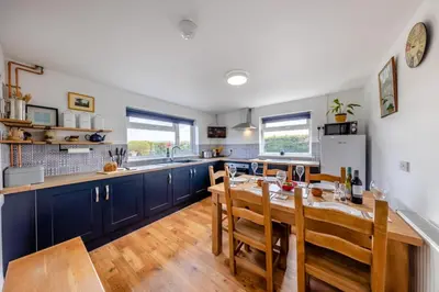 a kitchen with a wooden table and blue cabinets at 3 Bed in Llanrhystud oc-m28913 in Llanrhystyd