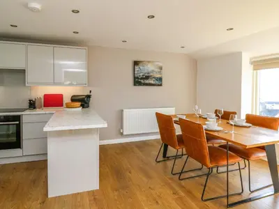 a kitchen and dining room with a table and chairs at 1 Gibraltar Terrace in Aberdyfi