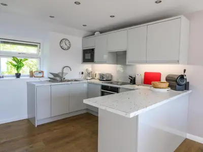 a kitchen with white cabinets and a counter top at 1 Gibraltar Terrace in Aberdyfi