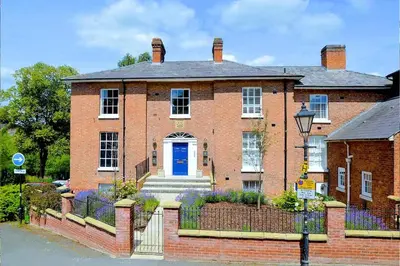 a large brick house with a blue door at Beautiful Town Centre Apartment 110 Square Metre With Parking WEEKLY and MONTHLY Reduced Rates in Shrewsbury