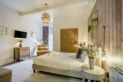 a bedroom with a large bed and a living room at Beautiful Town Centre Apartment 110 Square Metre With Parking WEEKLY and MONTHLY Reduced Rates in Shrewsbury