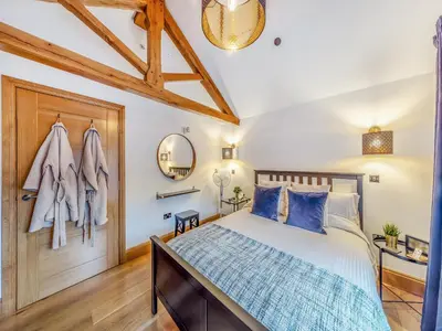 a bedroom with a bed with blue pillows at The Oaks in Llangollen