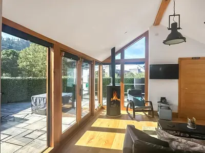 a living room with a fireplace and a patio at The Oaks in Llangollen