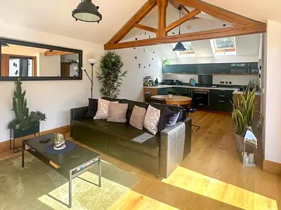 a living room with a couch and a kitchen at The Oaks in Llangollen
