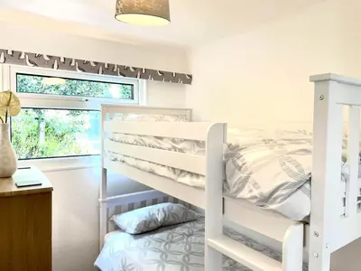 a bedroom with a bunk bed and a window at Chalet 8 The Woodlands in Tywyn
