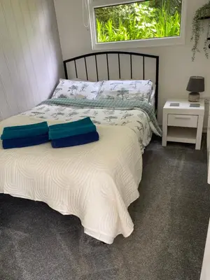 a bed with two pillows on it in a bedroom at Chalet 8 The Woodlands in Tywyn