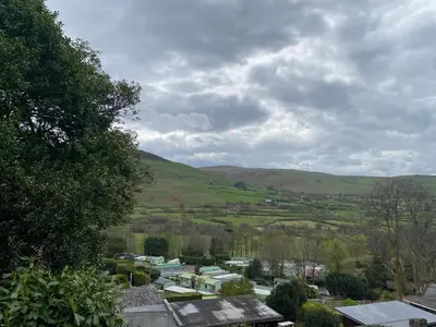 a view of a town with hills in the distance at Chalet 8 The Woodlands in Tywyn