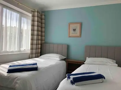 two beds sitting next to each other in a bedroom at Snowdonia coastal getaway ideal for groups up to 6 in Llwyngwril