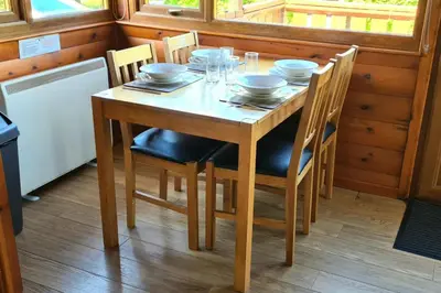 a wooden table with bowls and plates on it at Cosy log cabin in Snowdonia 19 in Trawsfynydd