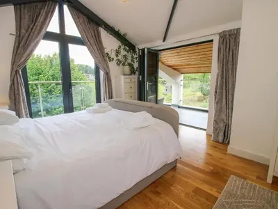 a bedroom with a white bed and a large window at Timberdyne in Ludlow