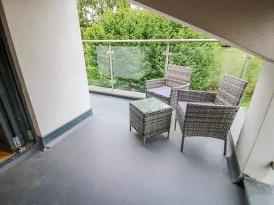 a balcony with chairs and a table and a window at Timberdyne in Ludlow