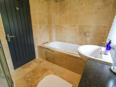 a bathroom with a tub and a toilet and a sink at Timberdyne in Ludlow