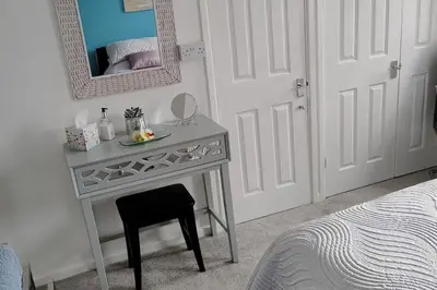 a table with a mirror and a chair in a bedroom at Ludlow Mews Town House with Free parking in Ludlow